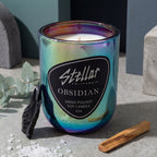 “Chromatic Obsidian candle reflecting blue, purple, and green tones.”